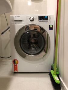 a washing machine with a broom in a room at Flat Versatti - Próximo Real Hospital Port e Pólo Médico Ilha do Leite in Recife