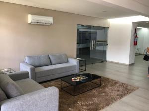 a living room with two couches and a coffee table at Flat Versatti - Próximo Real Hospital Port e Pólo Médico Ilha do Leite in Recife