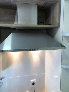 a stove hood in a kitchen with a light at Flat Versatti - Próximo Real Hospital Port e Pólo Médico Ilha do Leite in Recife