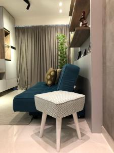 a living room with a blue couch and a table at Flat Versatti - Próximo Real Hospital Port e Pólo Médico Ilha do Leite in Recife