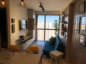 sala de estar con sofá azul y ventana grande en Flat Versatti - Próximo Real Hospital Port e Pólo Médico Ilha do Leite, en Recife