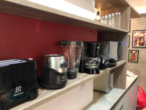 a kitchen counter with various appliances on a shelf at Flat Versatti - Próximo Real Hospital Port e Pólo Médico Ilha do Leite in Recife