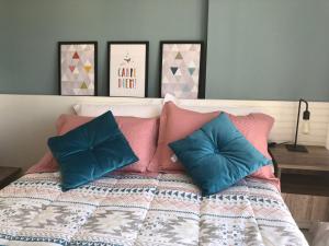 1 dormitorio con 1 cama con almohadas rosas y azules en Flat Versatti - Próximo Real Hospital Port e Pólo Médico Ilha do Leite, en Recife