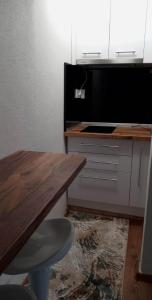 a kitchen with a wooden table and a counter with a tableablish at Átutazó Apartman in Nyíregyháza +7 photos