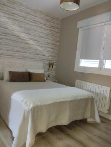 um quarto com uma grande cama branca e uma janela em CASA LAXE DO BARRO em Cangas