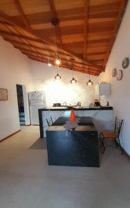a kitchen with a table and chairs in a room at Sonia Flats - Chalé a 500 metros da Praia da Tartaruga in Búzios