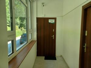 korytarz z drewnianymi drzwiami i oknem w obiekcie Słoneczna Równica w Ustroniu