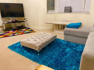 sala de estar con sofá y alfombra azul en Large Executive 4-Bed Detached House in Miskin, Cardiff-sleeps up to 10, en Hensol