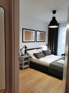 sypialnia z łóżkiem i biurkiem z lampką w obiekcie APARTAMENT GDAŃSKA FLORA w Gdańsku