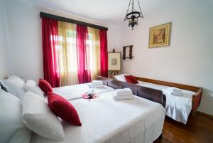 a room with two beds and a table with red pillows at Wind & Water in Delnice