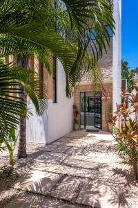 a house with a palm tree in front of a door at Wonderful Tropical Home 3BR, Garden, Private Pool. in Tulum