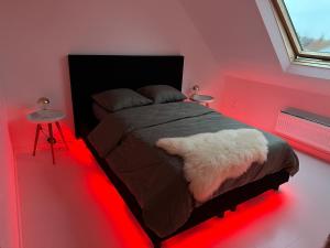 a bedroom with a bed with red lights on it at Antwerp West Side Attic in Zwijndrecht