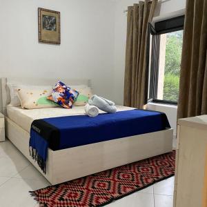 a bedroom with a bed with blue sheets and a window at MetaB&B in Gusmar
