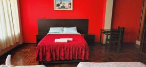 a red bedroom with a bed with a red blanket at HOSPEDAJE CALLAO in Tacna