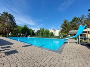 een blauwe glijbaan in het midden van een zwembad bij 3 Studios - 3 Ambiances - Tout confort - Chez Maud et Danny - Piscine extérieure chauffée ouverte en Juillet et Août in Han-sur-Lesse