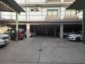 un garaje con coches estacionados frente a un edificio en Bari en Mendoza