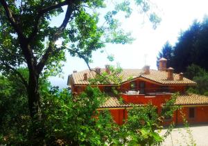 ヴェッレトリにあるAgriturismo Il Falcoの目の前に木々が生える赤い家