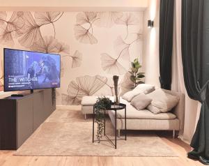 a living room with a tv and a couch at W83 Como Lake House in Como