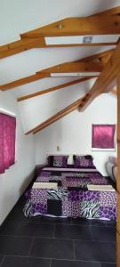 two beds in a room with purple pillows at Melissa 1Apartman in Rakovica