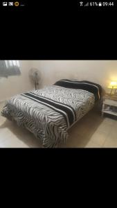 a zebra print bed in a room with a lamp at Casa REYES JUJUY in Reyes