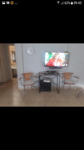 a living room with a tv and a table and chairs at Casa REYES JUJUY in Reyes