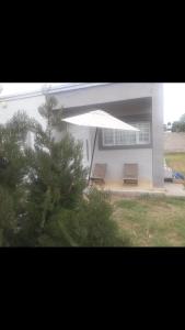 a house with two chairs and a tree in front of it at Casa REYES JUJUY in Reyes