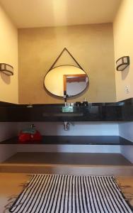 a bathroom with a sink and a mirror at Sonia Flats - Chalé a 500 metros da Praia da Tartaruga in Búzios