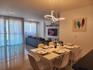 a dining room and living room with a table and chairs at FORTALEZA APTo INTEIRO 5 HOSPEDES in Fortaleza