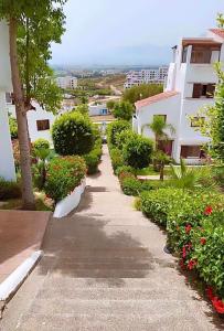 a walkway in a city with flowers and buildings at Apartement cabo in Tétouan