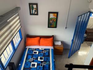 a small bedroom with a bed and two windows at Hostal la luz de la colina in Filandia