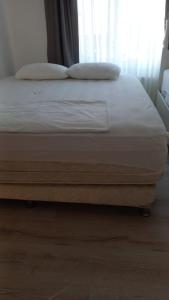 a bed with white sheets and pillows in a bedroom at Antalya Konyaaltı Plajında dublex GEMİ EV in Antalya