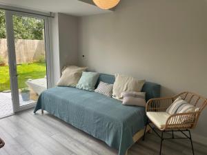 ein blaues Sofa in einem Zimmer mit Fenster in der Unterkunft Cornwall Tranquil Retreats in Saltash