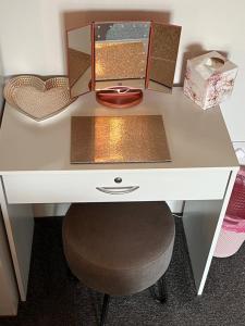 a white desk with a mirror and a stool at Vicki's Den in Tain