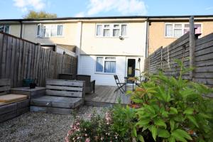 a backyard with a wooden deck and a house at Charming Four Bedroom Holiday Home in Harlow