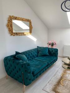 ein blaues Sofa im Wohnzimmer mit Spiegel in der Unterkunft Legato Apartment in Brčko