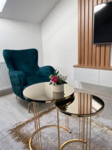 a living room with a blue chair and a table at Legato Apartment in Brčko