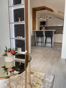 a kitchen and living room with a table with flowers on it at Legato Apartment in Brčko
