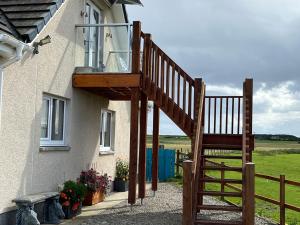 a wooden staircase leading up to a house at Vicki's Den in Tain