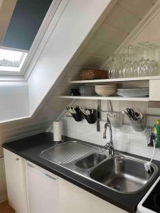 a kitchen with a sink and a counter top at Koselig garasjeloft! in Holen