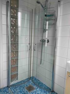 a bathroom with a shower with a glass door at Koselig garasjeloft! in Holen