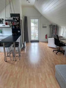 a living room with a wooden floor and a table and chairs at Koselig garasjeloft! in Holen