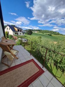 a balcony with a table and a view of a golf course at Ferienwohnung mit Weitblick in Nordhessen in Gudensberg