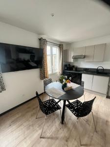 una cucina con tavolo e sedie in una stanza di Coin de paradis avec spa illimité en plein centre Avranches ad Avranches