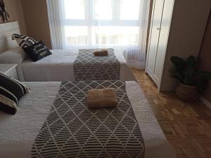 a room with two beds with towels on them at Piso céntrico Calma Costera in Santander