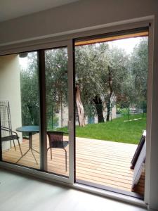 a sliding glass door with a view of a deck at La Casa sul Lago Apartments - Lemon Tree Apartment in Limone sul Garda