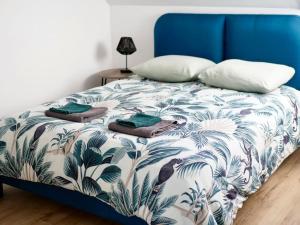 een blauw en wit bed met een blauw hoofdeinde en kussens bij ÉVASION JUNGLE - Wifi & Netflix ! in Mulhouse