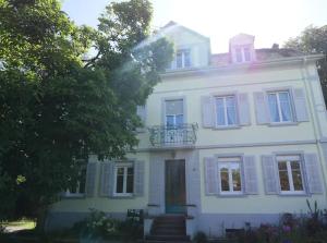a white house with a balcony on top of it at ÉVASION JUNGLE - Wifi & Netflix ! in Mulhouse