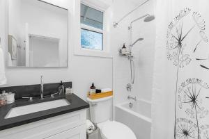 een witte badkamer met een wastafel en een douche bij The Greenwood Gem in Seattle +12 foto's