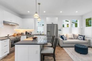 een keuken en een woonkamer met witte kasten en een bank bij The Greenwood Gem in Seattle