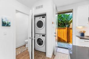 een witte wasruimte met een wasmachine en droger bij The Greenwood Gem in Seattle